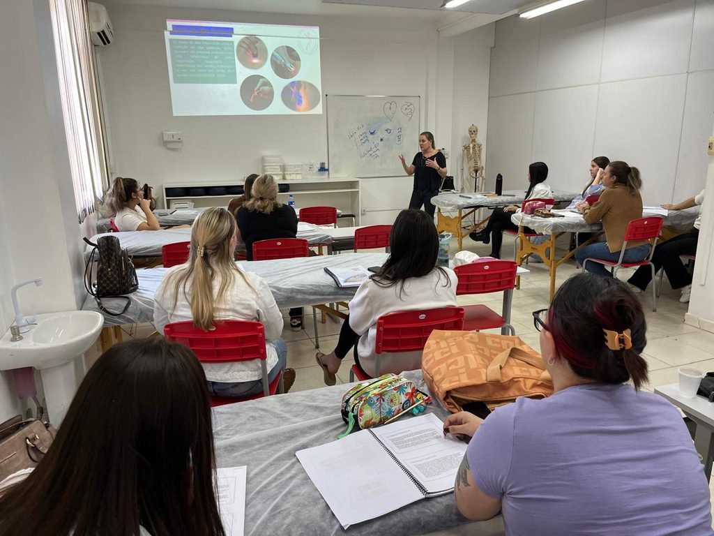 professora ministrando aula teórica de eletroterapia no Cursos profissionalizantes em Blumenau técnico em estética
